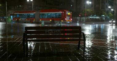 esvaziar Banco e estrada tráfego dentro a cidade às chuvoso noite video