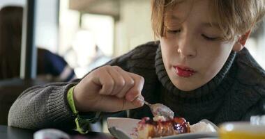 Boy eating berry pie for dessert in cafe video