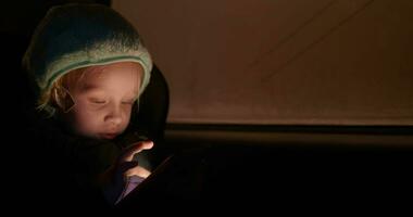 niño con móvil teléfono en el coche a noche video
