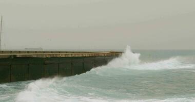 Rough ocean with waves crushing on breakwater video