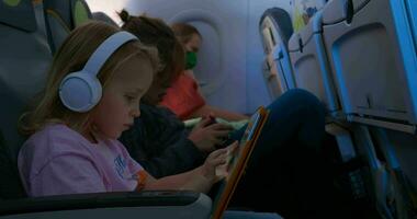 les enfants avec gadgets et en train de dormir mère dans le avion video