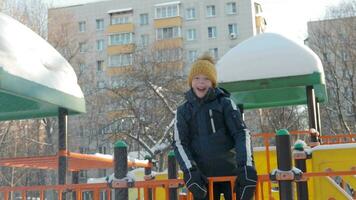 gelukkig en actief jongen de speelplaats in winter video