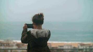Child taking scenic shots of ocean coast in Nazare, Portugal video