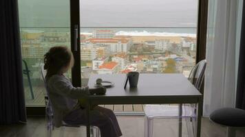 Child having breakfast and watching cartoons in the apartment with ocean view video