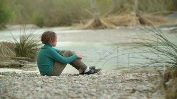 Boy throwing stones into the river video