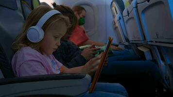 Sleeping mother and kids with gadgets traveling by plane video