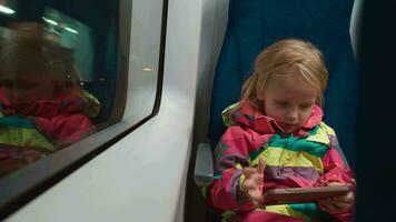 poco ragazza passeggeri con Telefono in viaggio di treno video