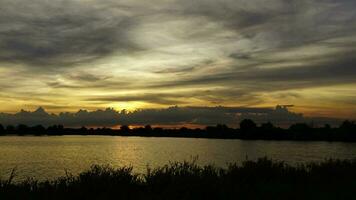 Time lapse Sunset behind a moving cloud. Gives a beautiful golden light above the marshes. video