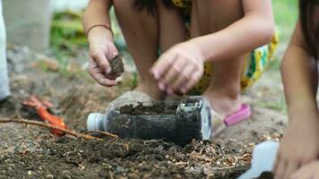 peu fille plantation les plantes dans des pots de recyclé l'eau bouteilles dans le cour. recycler l'eau bouteille pot, jardinage Activités pour les enfants. recyclage de Plastique déchets video
