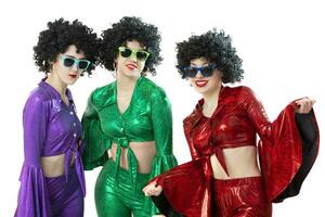 A group of disco girls in African American wigs and colorful costumes on a white background. Fashion of the seventies and eighties. photo