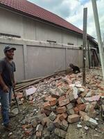 Kuaro Kalimantan Timur, Indonesia 10 September 2023. builders are demolishing a brick wall photo