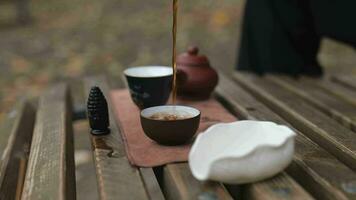 torrencial té desde un vaso taza dentro té bochas. al aire libre té ceremonia video