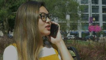 Aziatisch vrouw Aan telefoon in park video