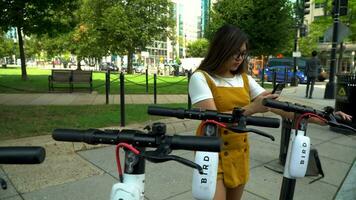 Washington, dc, 2019 - giovane donna sceglie scooter per cavalcata per città universitaria video