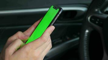 main en portant mobile téléphone vert écran à voiture, en utilisant téléphone à voiture, téléphone intelligent vert écran video