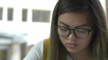 luta upp till ung kvinna studerar för testa och tar anteckningar för företag skola video