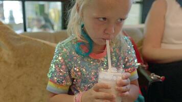 Kid drinking delicious milkshake in cafe video