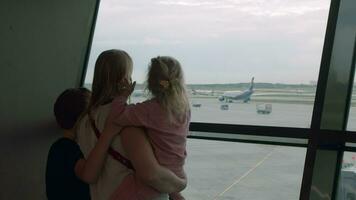 Mother with curious kids waiting for flight at the airport video