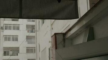 une femme des stands sur le balcon et regards à le pluie video