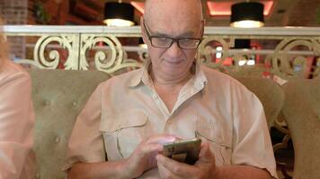 senior Mens met telefoon in de restaurant video