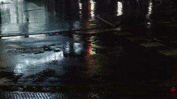 chuvisco, poças e noite urbano luzes refletindo em a estrada video
