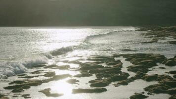 Lanzarote coastline with ocean waves washing volcanic stones, scene in sunlight video