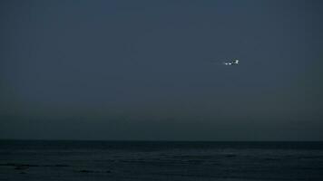 avión viniendo en para un aterrizaje terminado el océano, noche ver video