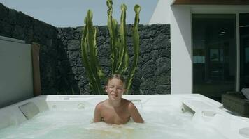 Kid relaxing in outside spa bath video