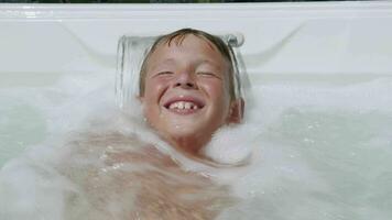 Hydromassage is so exciting. Child having fun in spa tub video