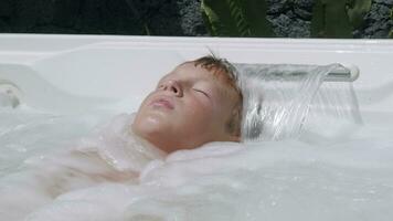 un' ragazzo rilassante nel un' vasca idromassaggio video