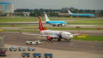 amsterdam, le Pays-Bas juillet 30, 2017 - Boeing 737 de corendon néerlandais compagnies aériennes vriendenloterij livrée à Amsterdam aéroport. remorquage tracteur et aéroport Personnel sur le aérodrome. video