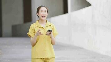 mujer participación teléfono inteligente y saludo amigo en frente de centro comercial edificio video
