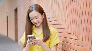 Japonais femme à la recherche à téléphone intelligent à chercher pour information dans application video