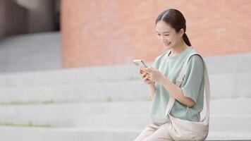 Université fille séance et bavardage sur social médias téléphone intelligent video