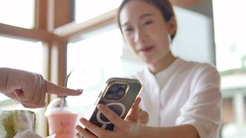 asiático joven mujer sentado en café Bebiendo café con amigos y hablando juntos video