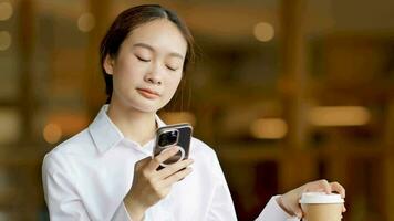 asiático mujer hablando en el teléfono en social medios de comunicación con un taza de café video
