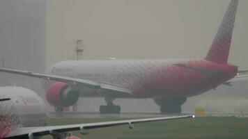 Moscou, russo federação Julho 28, 2021 - boeing 777 31ela, ei geu do rossiya taxiando às sheremetyevo aeroporto. pesado pesado chuva criando pobre visibilidade em a aeródromo video