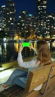 donna prende immagini di il grattacieli di vancouver su sua smartphone a notte video
