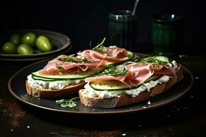 Sandwiches with cream cheese prosciutto cucumber and arugula on plate photo