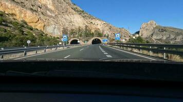 auto reis langs toneel- weg en het rijden door de berg tunnel video