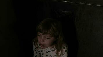 fille de 8 ans est étreindre le poupée séance dans le obscurité video
