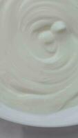 Yogurt in a turning plate. Closeup video