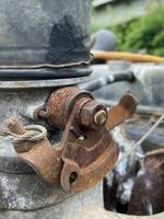 old and rusty valve on the background of old rusty pipe photo