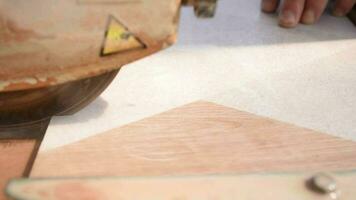 Close-up of a man cutting tiles and granite with an electric circular saw and applying water to it video