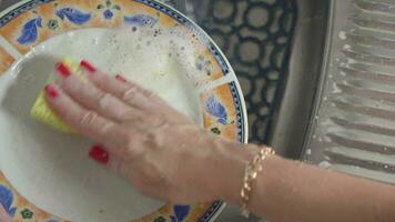 aux femmes mains laver sale vaisselle avec détergent et éponge. video