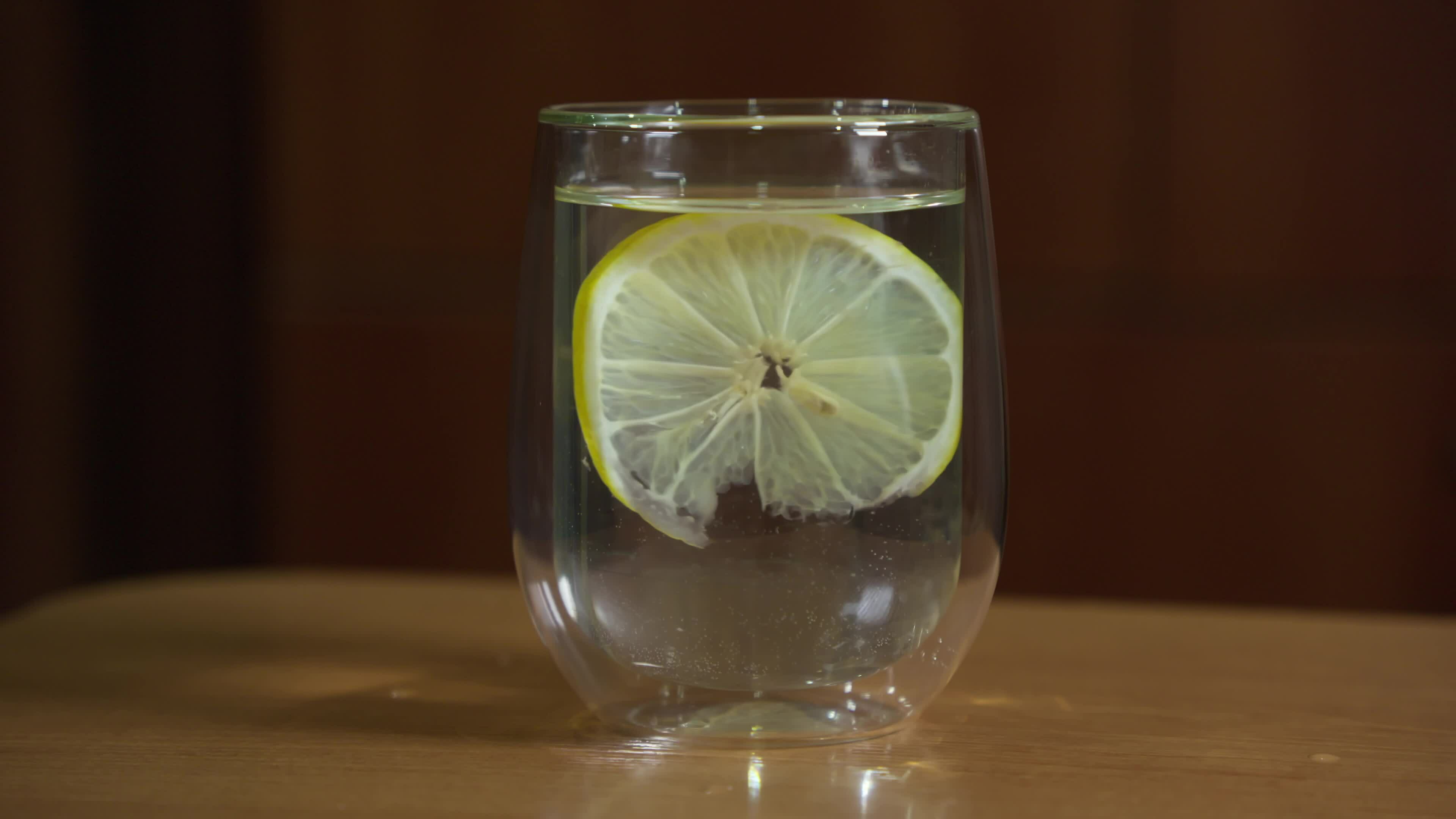 Clean drinking water with lemon floating in it in a transparent glass