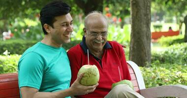 Video of father and son drinking fresh coconut water in park