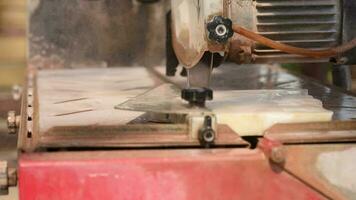 Close-up of a man cutting tiles and granite with an electric circular saw and applying water to it video