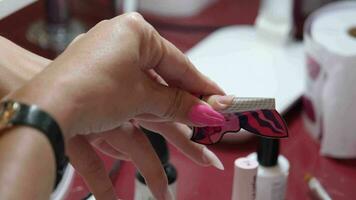 From above of crop unrecognizable manicurist doing nail art for female client in beauty salon video