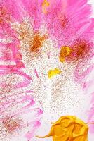 On a white background, pink streaks of watercolor are sprinkled with gold sparkles. photo